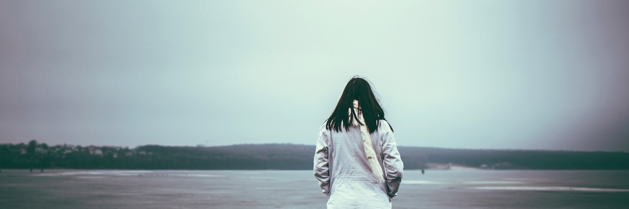 Intentions for the New Year From a Lyme Warrior Woman wearing jacket, facing winter landscape and frozen lake