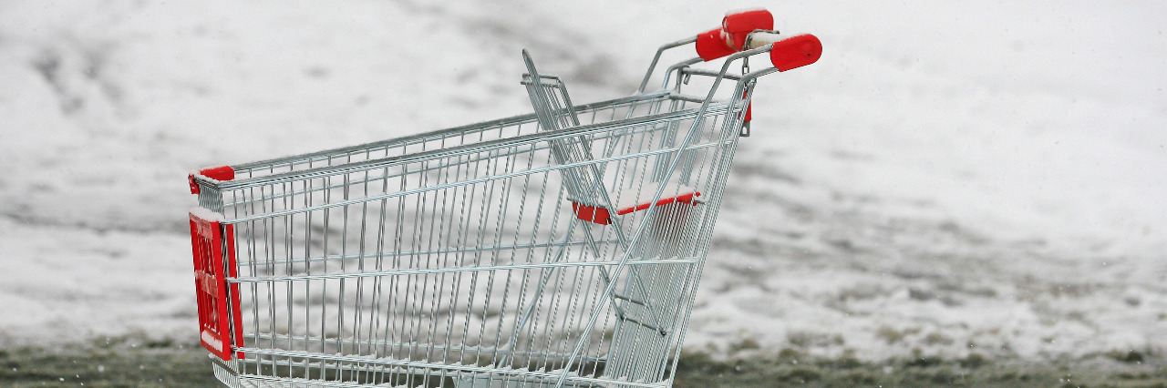 Supermarket shopping cart outside in snow.