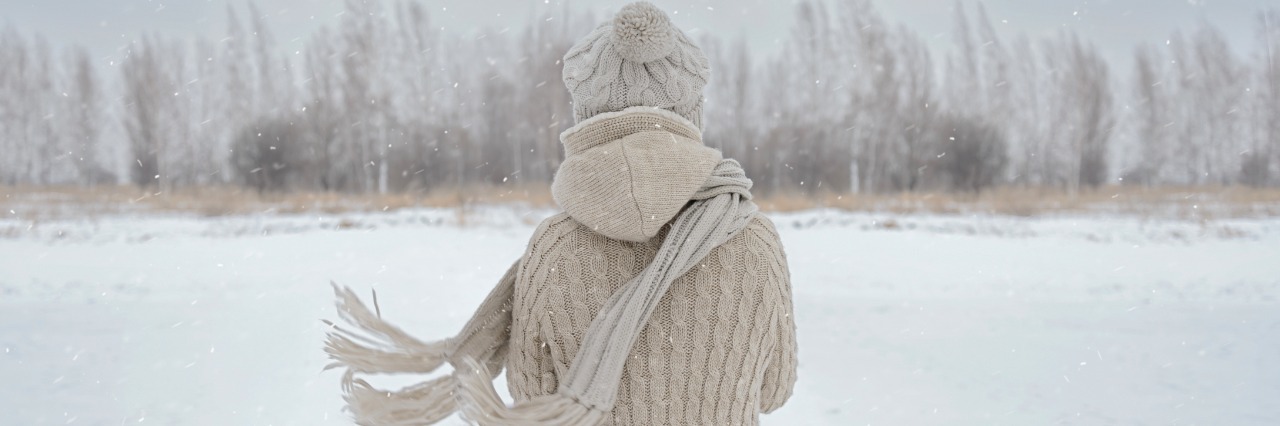 back of woman standing on snowy field