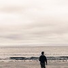 Picture of man from behind walking on a beach