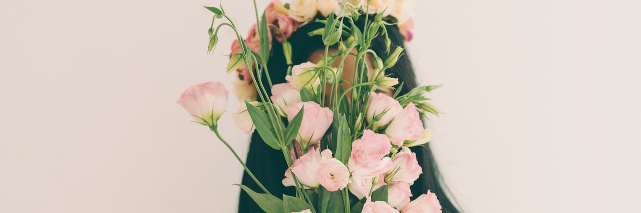 a girl hiding behind flowers