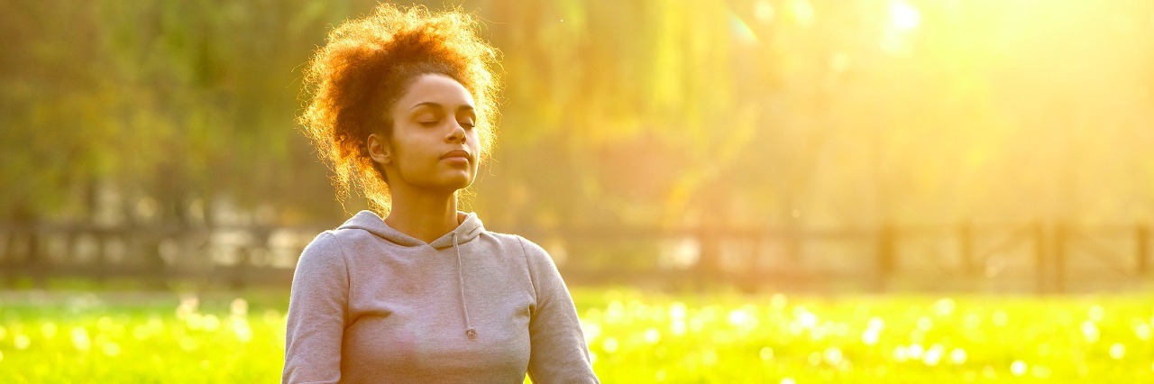 Accepting the Reality of My Undiagnosed Illness Young woman meditating in nature