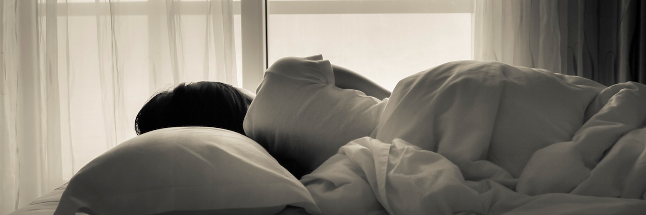 Waking Up With Grief Woman lying in bed, facing the window