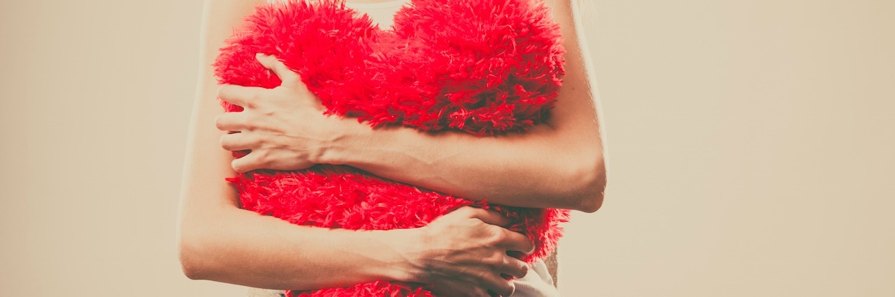 Getting Through a Breakup With Borderline Personality Disorder A woman holding a heart pillow