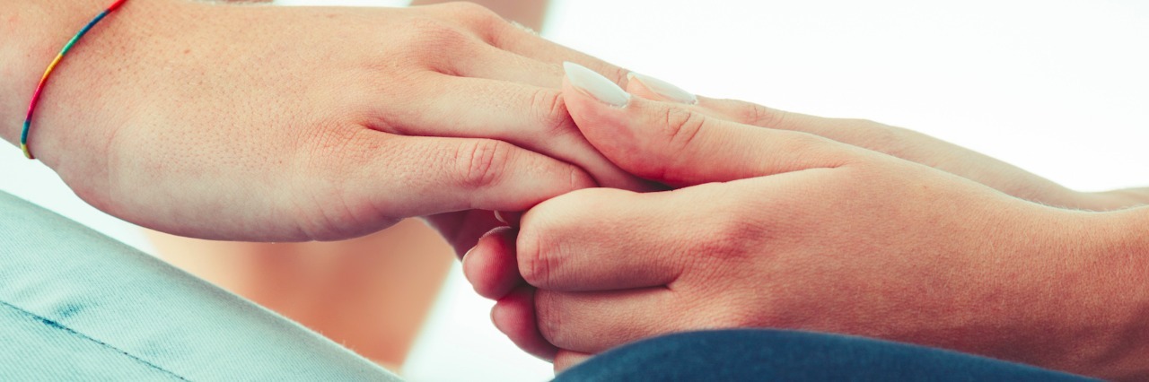 Close-up photo of person holding another person's hands