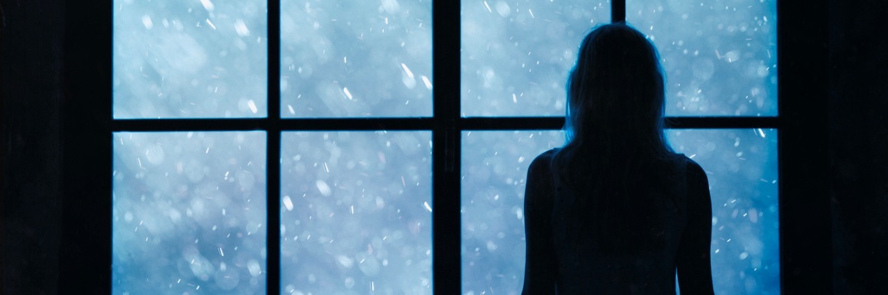 A Letter to Anyone in Pain or Feeling Alone at Christmas Lonely women looking at snowfall through big glass window