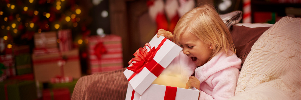 Fun and Therapeutic Holiday Gifts for Children With Disabilities Child opening present on Christmas morning.