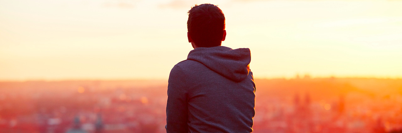 How I Found Hope in My Struggle With Mental Illness Young man is looking at the sunrise