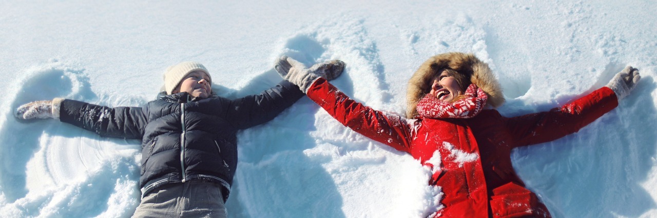 How to Support a Child on the Autism Spectrum During the Holidays mother and son making snow angels