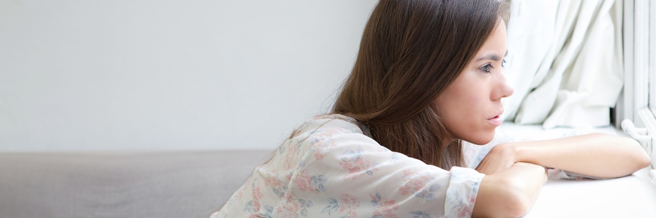 Transitioning From Adolescence to Adulthood with a Chronic Illness woman gazing longingly out her bedroom window