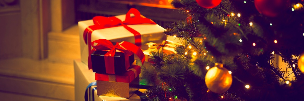 Gift Ideas for People With Chronic Fatigue photo of decorated Christmas tree and gift boxes against burning fireplace