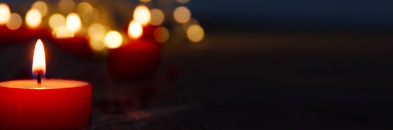 Getting Through the Holidays After Loss Lit red candles against a dark background