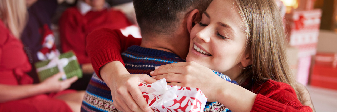 Things on a Person With Hypotonia's Holiday Wishlist Girl hugging relative at holiday gathering.