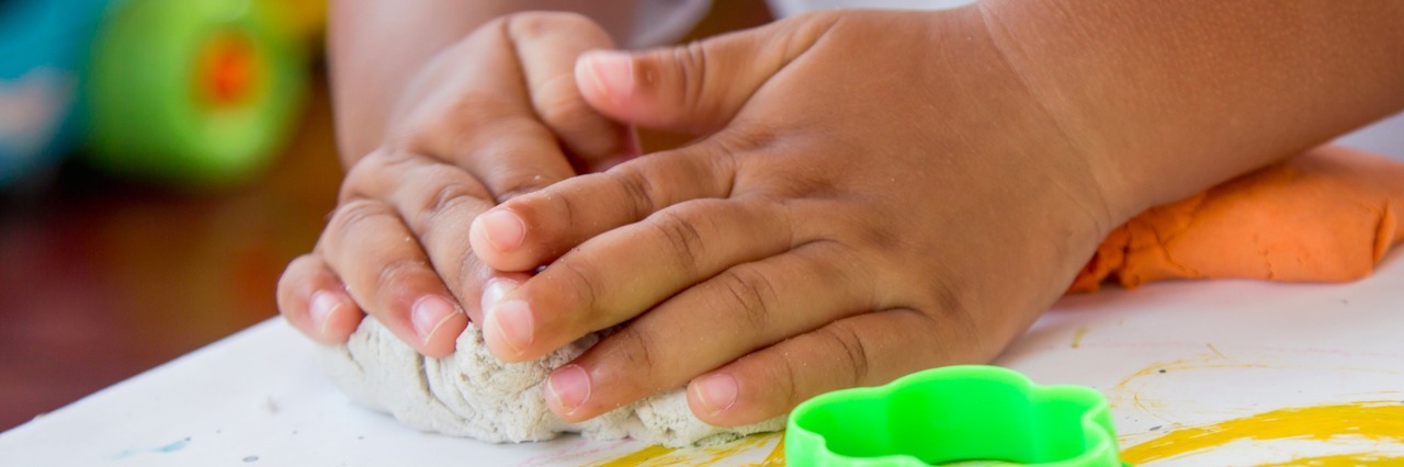 Nail-Trimming Tips for Kids With Sensory Sensitivities Child's hand playing with clay, play doh