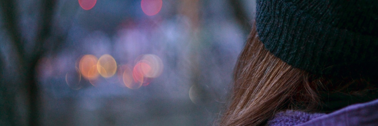 Grief and Depression During the Holiday Season Woman watching city lights through tree branches