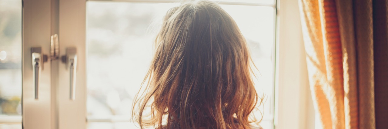 Adjusting to Life Changes After Chronic Illness Woman looking out window at home