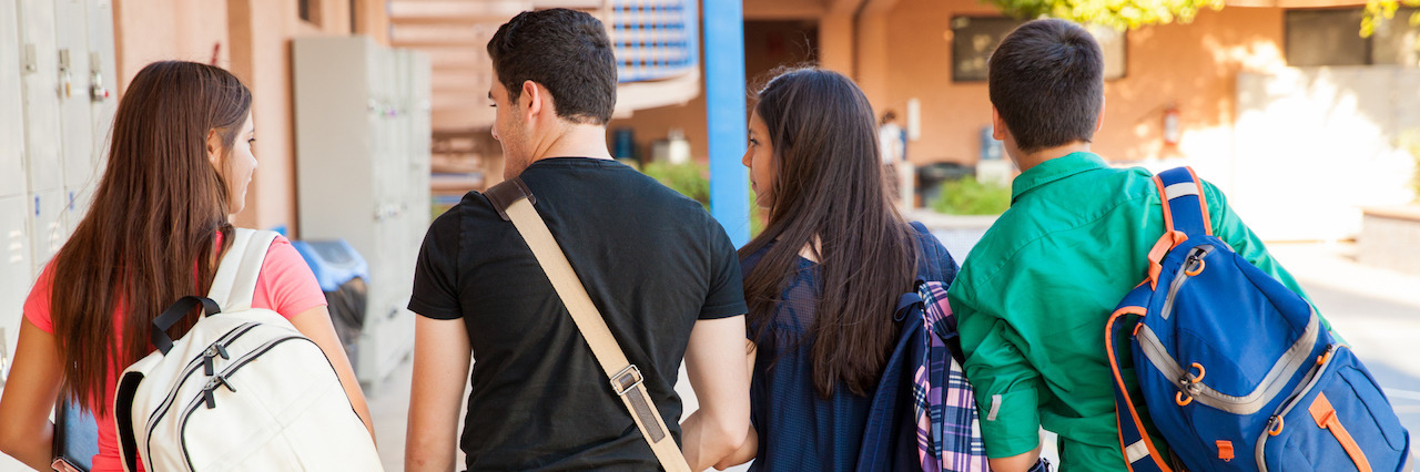 Why Talking to High School Students About Mental Illness Matters Rear view of a bunch of high school students walking down the hallway