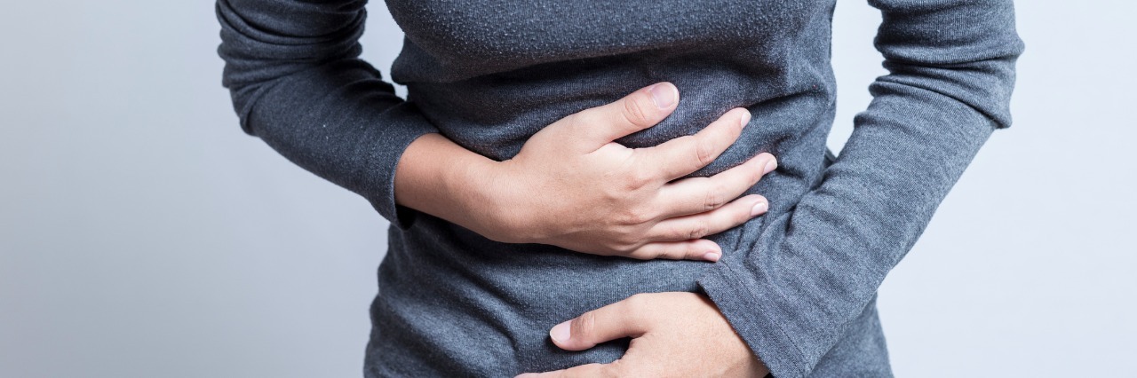 Raising Awareness for Ulcerative Colitis and Crohn's Disease woman holding her stomach in pain