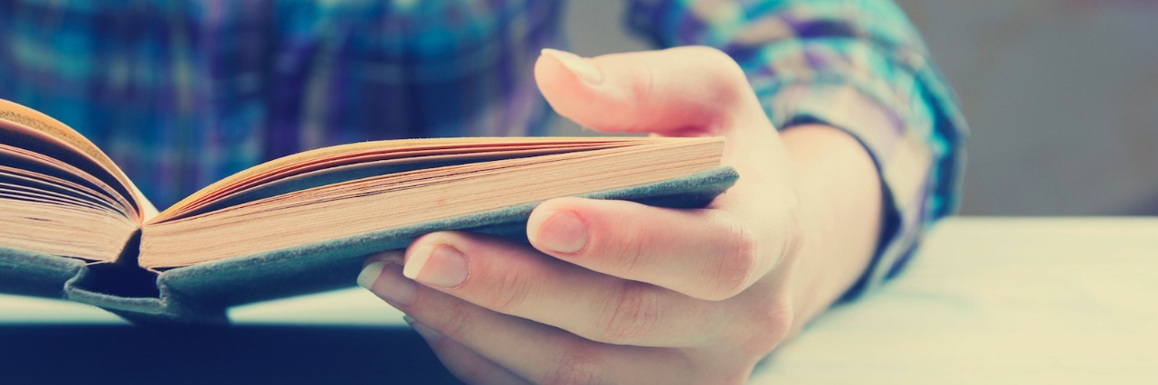 Close-up of open book and person reading it