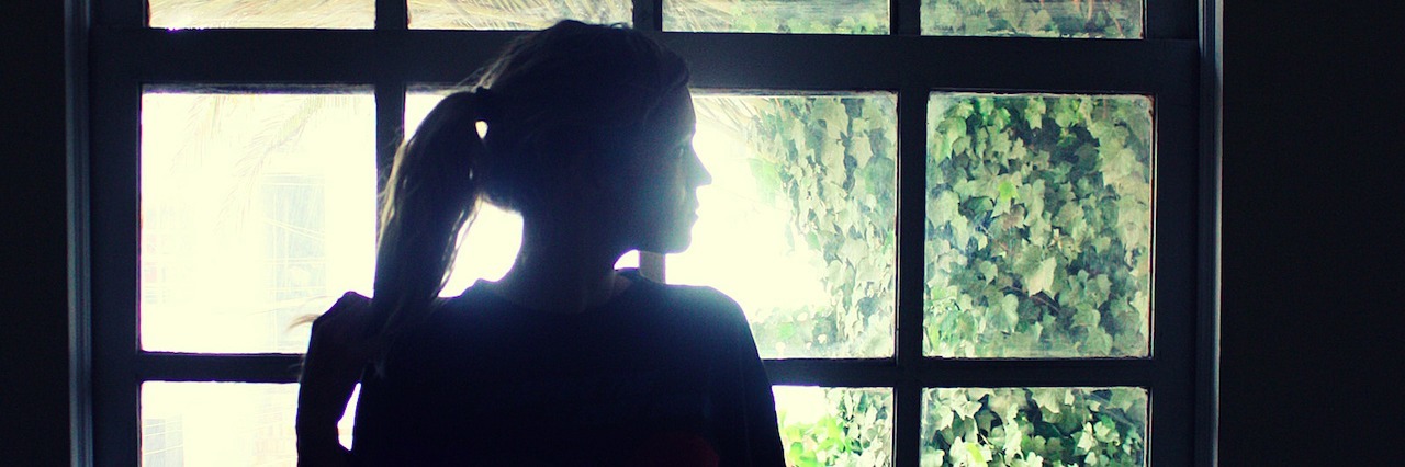 How My Life Changed After My Brother Died by Suicide woman standing by a window