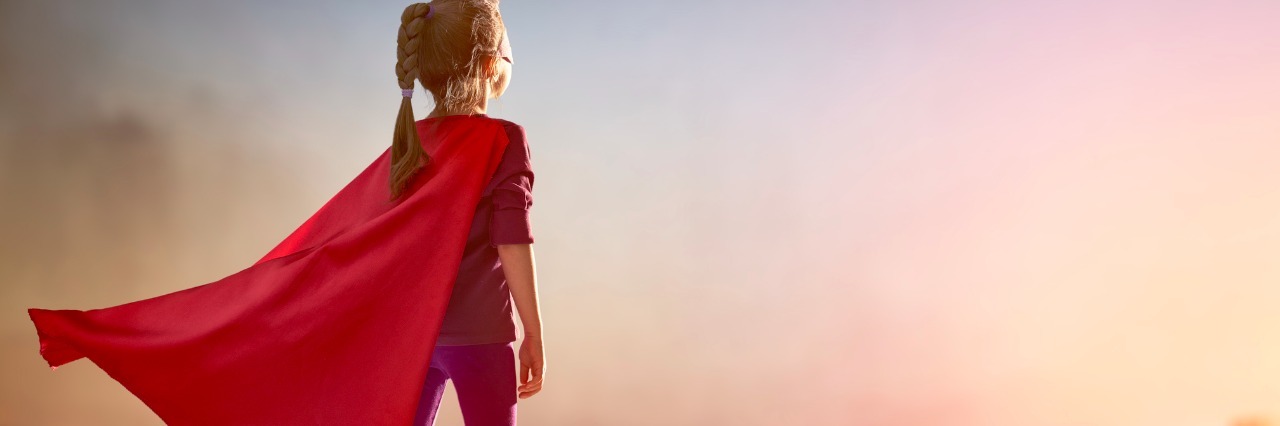 girl dressed as superhero on building roof