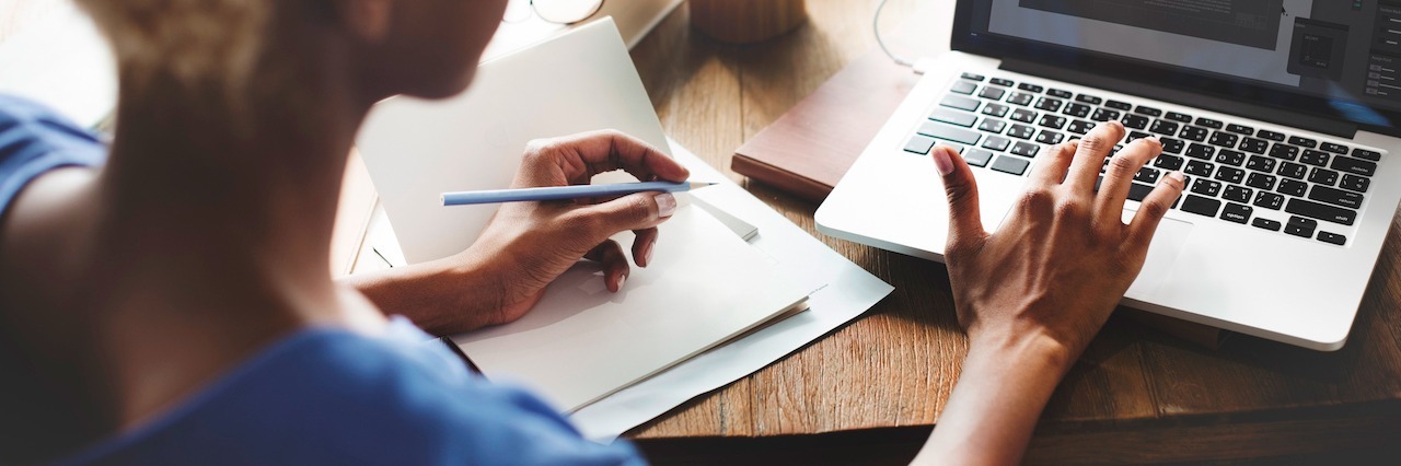 How Depression Hurst Creative and Professional Ambitions A woman on a computer writing in a notebook