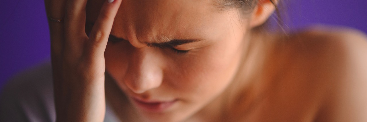 What Migraines Feel Like, to Those Who Think They 'Can't Be That Bad' Teen woman with headache holding her hand to the head