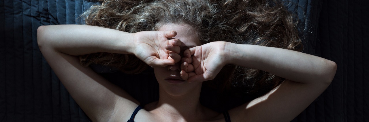 When It Feels Like Depression Is Winning woman lying on a bed covering her eyes