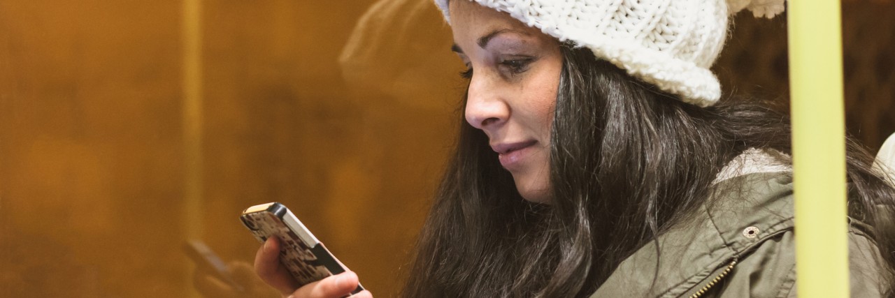 Teen With Dysautonomia Responds to Looks for Using Disability Seats Young adult female spends time with her smartphone on bus