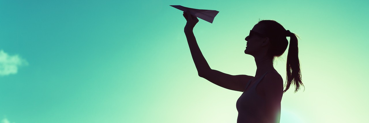 5 Resolutions for Mental Health Recovery Beautiful silhouette of young woman throwing paper airplane.