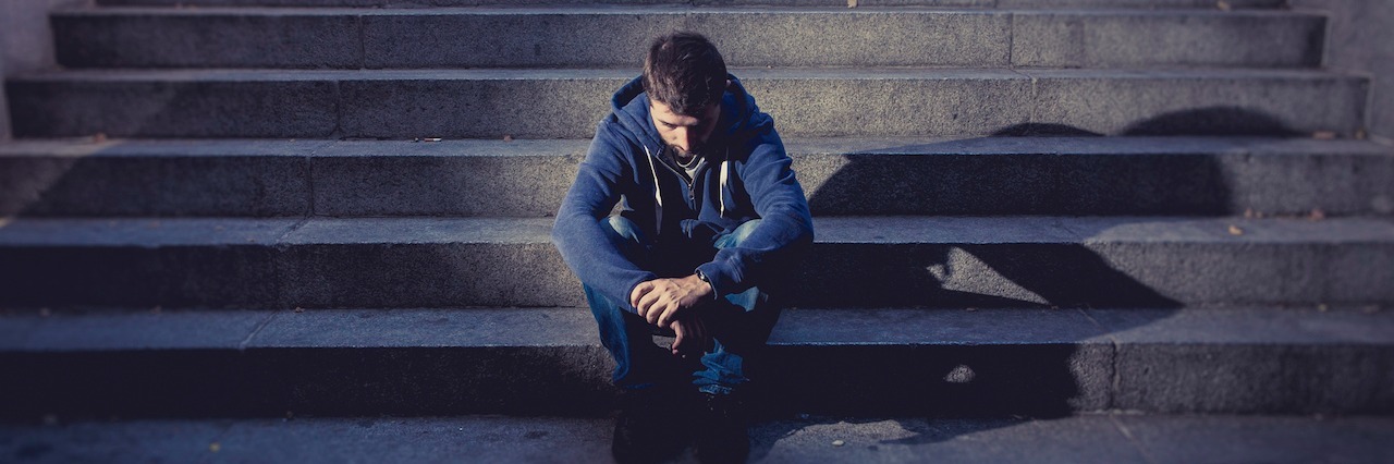 How I Recovered From Trauma After a Robbery young man sitting along on stairs