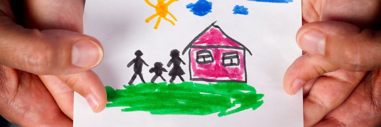 Child and his mom holding a drawn house with family