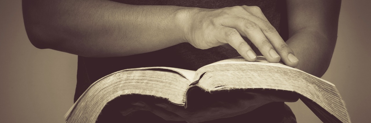 When Religion and Mental Health Treatment Are at Odds close up of man holding a bible in his hands and turning the page