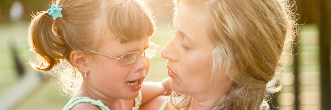 Calming Strategies for Meltdowns mother comforts crying daughter outdoors