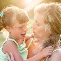 mother comforts crying daughter outdoors