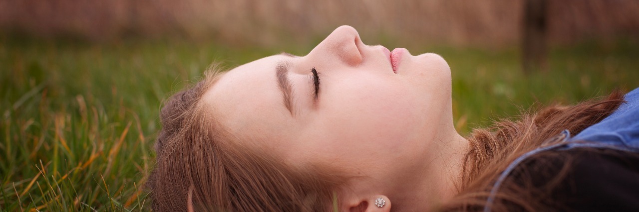 When You Want and Don't Want People to Notice Your Anxiety teenage girl lying on grass with her eyes closed
