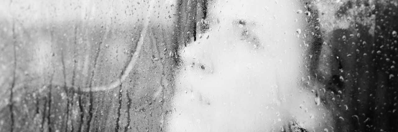 a womans face blurred through a window