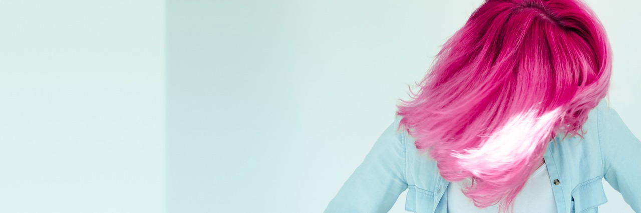 How Dyeing My Hair Saved Me From My Eating Disorder Woman with bright colored hair looking down