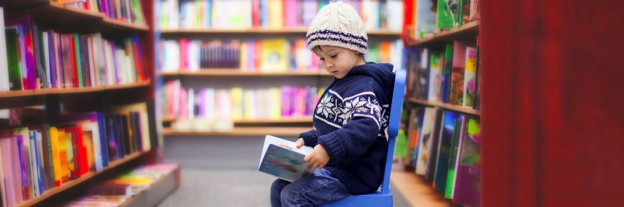 adorable little boy sitting in a book store