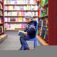 adorable little boy sitting in a book store