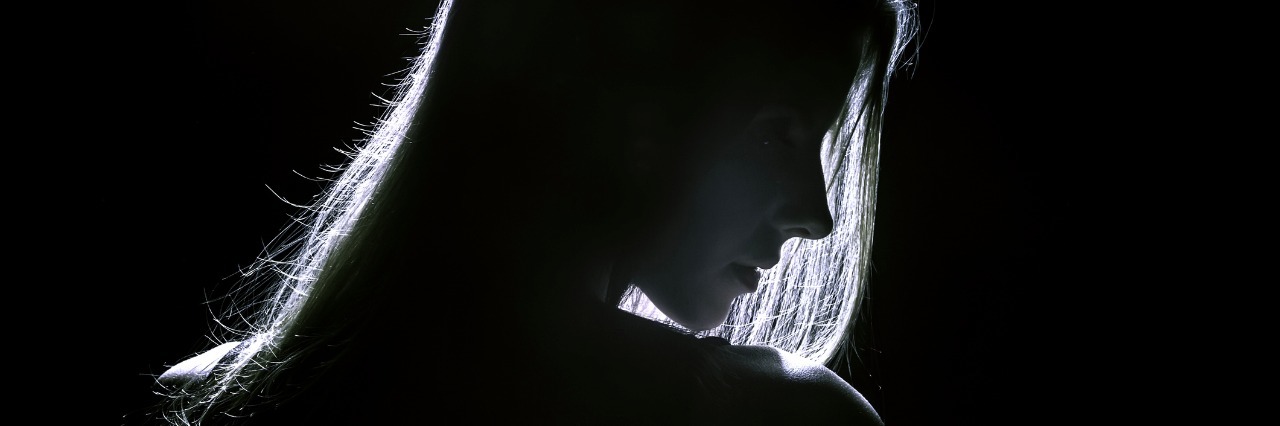 What Emotional Blackouts Are Like With Borderline Personality Disorder sad woman profile silhouette in dark
