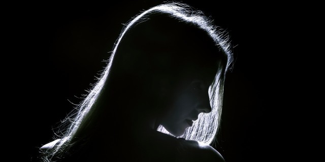 sad woman profile silhouette in dark