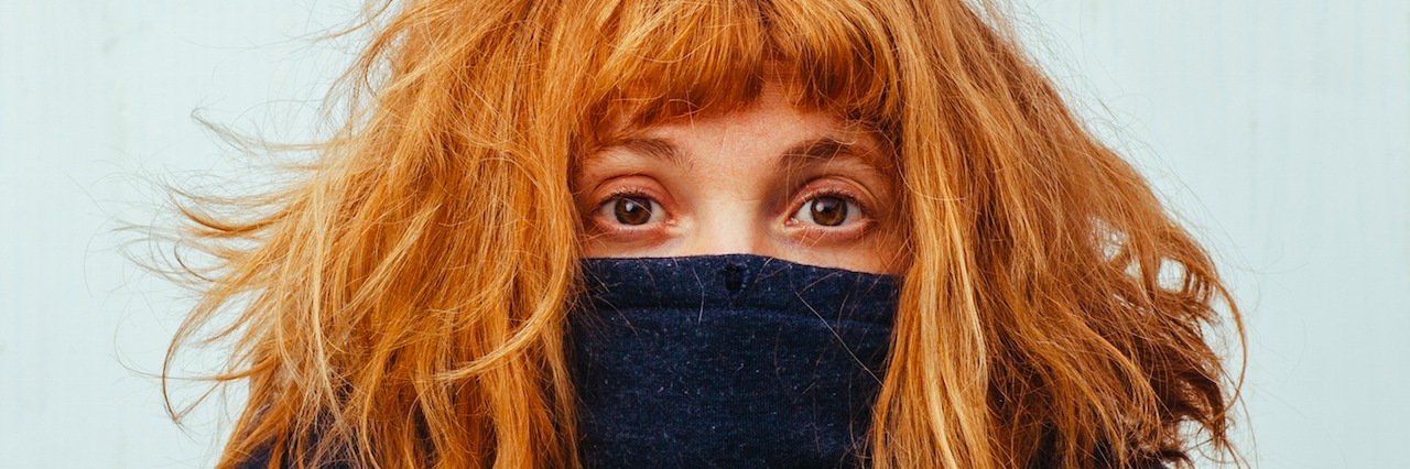 Social Anxiety: What It's Like to Be Afraid of People a woman hides behind her sweater