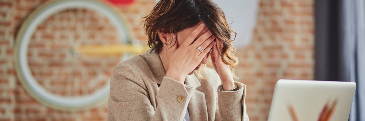 The (Not-So) Silent Workplace Battle With Anxiety woman getting a Headache In Office