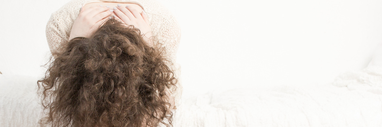 Morning Thoughts With Depression and Anxiety Sad girl sitting on the bed with her head down and covering her face with her hands