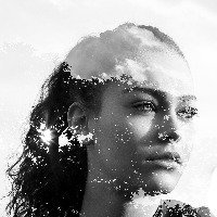 double exposure of a woman looking into the distance and black and white leaves