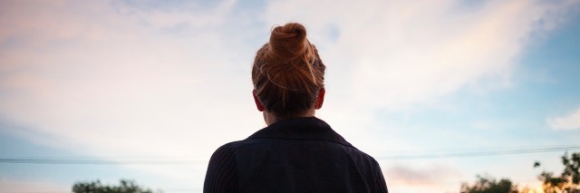 silhouette of a young woman looking at sunset