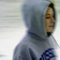 Side profile of a young woman wearing hooded shirt