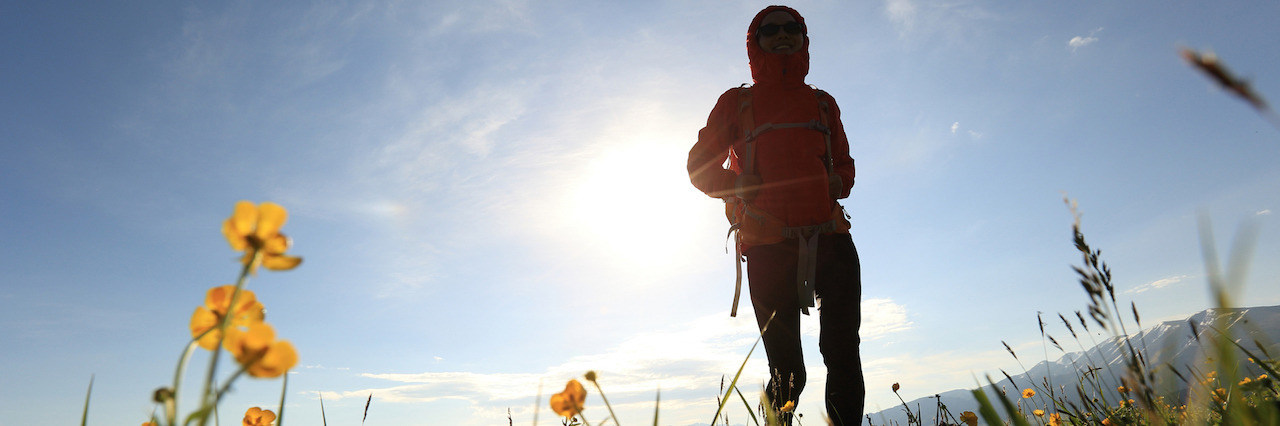 What I Wish People Understood About Life With PTSD and Anxiety silhouette of young woman backpacker hiking on sunrise mountain peak