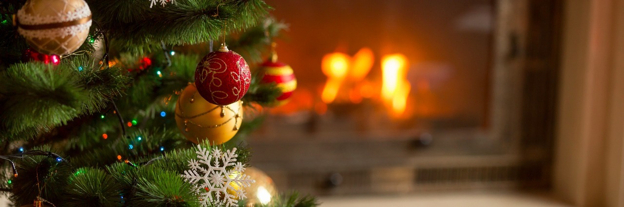 Coping With Christmas After the Loss of Parents closeup image of golden baubles on Christmas tree at fireplace